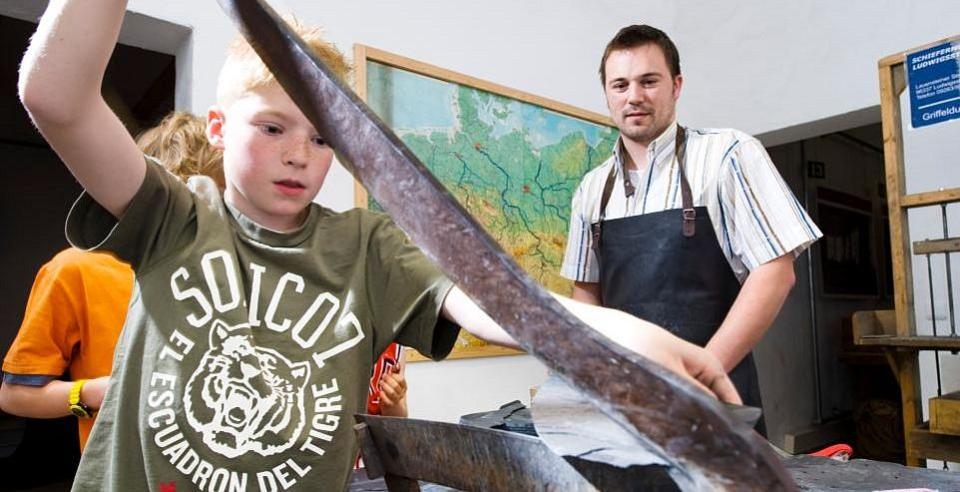 Junge hilft mit im Schiefertafelmuseum